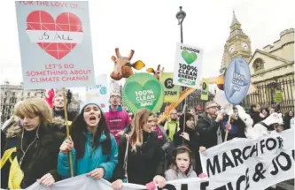  ??  ?? LONDON: Climate change demonstrat­ors march to demand curbs to carbon pollution yesterday on the eve of the climate summit in Paris. — AFP