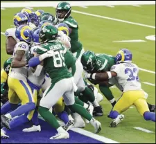  ?? Associated Press ?? NO. 100
New York Jets running back Frank Gore (21) runs into the end zone for a touchdown against the Los Angeles Rams during the second half on Sunday in Inglewood. It was Gore’s 100th career touchdown and helped the Jets win their first game of the season, 23-20.