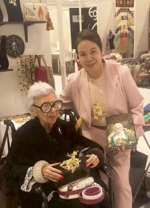  ??  ?? Apfel holding Ann Ong’s one-of-a-kind minauderie, and on her lap the Gianinna round bag with bird design