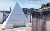  ??  ?? Actor Nicolas Cage owns this gleaming tomb shaped like a pyramid in St. Louis Cemetery No. 1. The white 9-foottall structure bears the words “omnia ab uno,” which is Latin for “everything from one.”