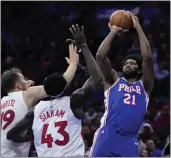  ?? MATT SLOCUM — THE ASSOCIATED PRESS ?? The 76ers' Joel Embiid, who had 28points, goes up for a shot against the Raptors' Pascal Siakam and Jakob Poeltl.