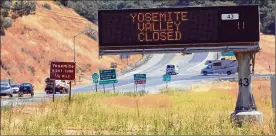  ?? JIM WILSON / THE NEW YORK TIMES ?? A sign near California’s Yosemite National Park warns motorists last month that Yosemite Valley was closed due to wildfires.