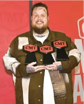  ?? CHRIS SAUCEDO/GETTY ?? Jelly Roll holds the three trophies he won Sunday at the CMT Music Awards in Austin, Texas.