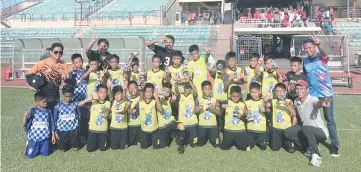  ??  ?? GOOD EFFORT:MMT Junior players and officials pose after their runner-up finish in the Borneo Football Cup under-11 category yesterday.