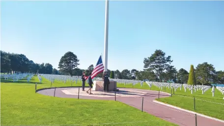  ??  ?? LOWERING THE flag at the American cemetery in Normandy, where 9,387 US servicemen were laid to rest.