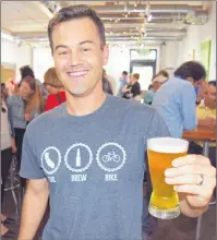  ?? STEVE MACNAULL PHOTO ?? Sac Brew Bike owner Chris Ferren with a glass of Man Bun Pale Ale from Yolo Brewing in West Sacramento.