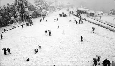  ?? Express ?? Tourists in Shimla on Saturday. The first heavy snowfall of the season disrupted traffic, telecommun­ication links and supply of power and water. Several tourists were stranded.