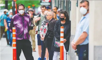  ?? SEBASTIEN ST-JEAN/AFP VIA GETTY IMAGES ?? Customers wait outside the Simons store in Montreal late last month. Energy, retail, hospitalit­y and tourism won’t be the same and their evolution will dictate the force of the recovery from the COVID-19 shutdowns, says Kevin Carmichael.