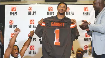  ?? | NATHAN HUNSINGER/ AP ?? Myles Garrett holds up a Browns jersey as his mother, Audrey ( left), cheers at his watch party in Arlington, Texas.