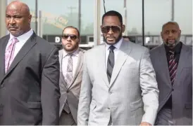  ?? ASHLEE REZIN/SUN-TIMES FILE ?? R. Kelly (third from left) walks with supporters out of the Leighton Criminal Courthouse in June 2019.