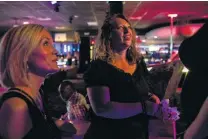  ??  ?? Lisa Michelle, left, founder of No Strings Attached, and volunteer Brook Singh talk with a dancer at a strip club. Michelle started the nonprofit ministry seven years ago.