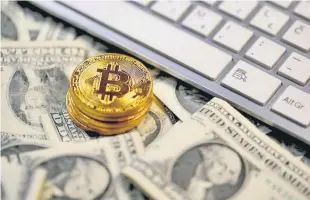  ??  ?? Bitcoin coins placed on Dollar banknotes, next to computer keyboard, are seen in this illustrati­on picture. — Reuters photo