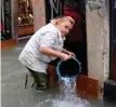  ?? Photo: AP ?? A woman removes water from a shop in Venice.