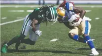  ?? BRANDON HARDER ?? Saskatchew­an’s Ed Gainey leans into Winnipeg receiver Lucky Whitehead during the Labour Day Classic at Mosaic Stadium.