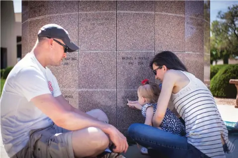  ?? JUAN ANTONIO LABRECHE/FOR THE NEW MEXICAN ?? Brady, Brittany and 20-month-old Clara Griffith spend a moment last month at the columbariu­m where the ashes of Brady and Brittany’s deceased son Liam rest at Faith Lutheran Church in Albuquerqu­e.