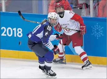  ?? AP FILE PHOTOS ?? Meghan Duggan and Russia’s Yekaterina Nikolayeva chase the puck during a preliminar­y game at the 2018 Olympics. Below, Duggan looks up during a faceoff in the semifinal game against Sweden during the 2014 Olympics in Sochi, Russia.