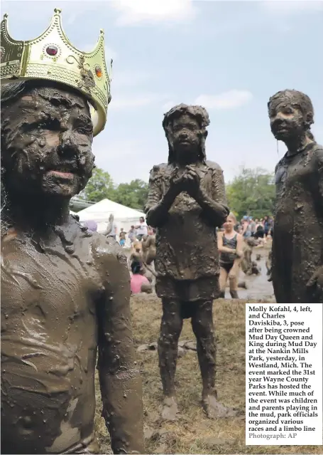  ??  ?? Molly Kofahl, 4, left, and Charles Daviskiba, 3, pose after being crowned Mud Day Queen and King during Mud Day at the Nankin Mills Park, yesterday, in Westland, Mich. The event marked the 31st year Wayne County Parks has hosted the event. While much of the event was children and parents playing in the mud, park officials organized various races and a limbo line Photograph: AP