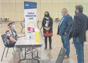  ?? FRANK GUNN THE CANADIAN PRESS ?? Dr. Eileen de Villa, Toronto’s medical officer of health, centre, Premier Doug Ford and Toronto Mayor John Tory tour the immunizati­on clinic at the Metro Toronto Convention Centre on Sunday.