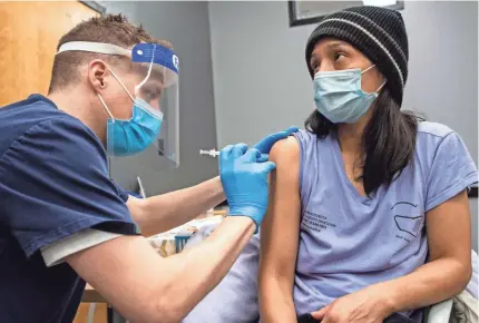  ?? JOSEPH PREZIOSO/AFP VIA GETTY IMAGES ?? Edith Arangoitia is vaccinated with the Pfizer-BioNTech COVID-19 vaccine at La Colaborati­va in Chelsea, Mass., on Feb. 16.