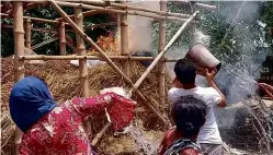  ??  ?? ABOVE:
Villagers in Choto Singia Munshipara try to douse one of the mysterious fires.