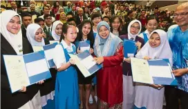  ??  ?? Sarawak education director Rakayah Madon (third right) together with a group of top achievers.
