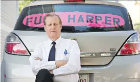  ?? THE CANADIAN PRESS/FILES ?? Rob Wells with his Stephen Harper sign. A judge has ruled the Edmonton man was stunting when he deliberate­ly pulled in front of other vehicles and drove below the speed limit so they would view his handmade sign.