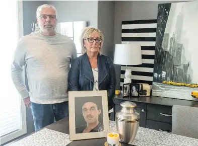  ?? QC PHOTO BY BRANDON HARDER ?? Wayne Wakelam and Jenny Churchill stand in Churchill’s home in front of a photo of their son, Jordan Wakelam, who struggled with an opioid addiction and died on Jan. 27, 2018, of an overdose.