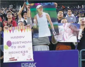  ?? PHOTOS BY XINHUA ?? Top: France’s Caroline Garcia (center right) poses with Ashleigh Barty of Australia (center left) after Saturday’s final of the Dongfeng Motors Wuhan Open. Garcia rebounded from a set down to win 6-7 (3), 7-6 (4), 6-2.
Above: Wuhan fans hold posters...