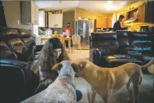  ?? NATHAN BURTON/Taos News ?? Adora Lopez plays with her dogs Shenzie and Kiwi while her father cooks dinner on Monday (March 7) in El Prado.