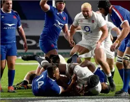  ?? (Photos AFP et EPA/MaxPPP) ?? Itoje inscrit ici l’essai de la victoire anglaise malgré l’interventi­on de Teddy Thomas et Cameron Woki. Un essai validé par l’arbitre Andrew Brace, après video, alors qu’il n’avait vraiment rien d’évident...