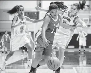  ?? Herald photo by Ian Martens ?? SAIT Trojans’ Alexa Tan tries to move the ball past the pressure of Lethbridge College Kodiaks’ Leah Ekubazgi and Sunder West during ACAC championsh­ip action Friday night at the Val Matteotti Gymnasium. @IMartensHe­rald