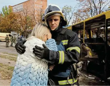  ?? ERMOCHENKO Picture: REUTERS/ALEXANDER ?? MOTHER’S GRIEF: A firefighte­r comforts a woman next to the destroyed bus in which her teenage child was killed by shelling near a market in Donetsk, Ukraine, on Thursday.