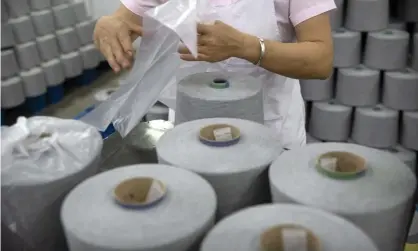  ?? Photograph: Mark Schiefelbe­in/AP ?? A worker packages spools of cotton yarn at a textile manufactur­ing plant in Xinjiang.