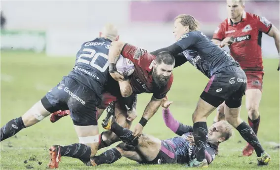  ??  ?? 2 Edinburgh No 8 Cornell du Preez crashes through the tackles of Sergio Parisse, left, and Charl Mcleod of Stade Francais in Paris on Saturday.