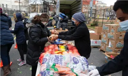  ?? Photograph: Michael Reynolds/EPA ?? Volunteers at Catholic Charities of Washington sort food items to distribute to those in need, December 2020.