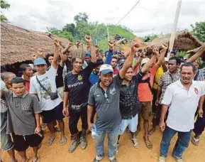  ?? [FOTO FATHIL ASRI/BH] ?? Limat (tengah) bersama penduduk ketika ditemui di Simpang Kampung Petei, Gua Musang, semalam.