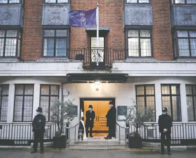  ?? DANIEL LEAL-OLIVAS / AFP VIA GETTY IMAGES ?? Police officers and doormen stand Wednesday at the King Edward VII hospital in central London where Britain's
Prince Philip, Duke of Edinburgh was admitted. The 99-year-old was taken to the private hospital on Tuesday.