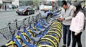  ??  ?? Locals scanned the code with mobile phones to ride shared bikes in Chengdu, Sichuan Province, on November 24, 2016. by Jiang Hongjing/Xinhua