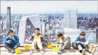  ??  ?? Constructi­on workers eat lunch near a board with an artist’s impression of the Central Business District outside a constructi­on site in Beijing, China, on April 6. Asia’s developing economies will see steady growth this year and the next, though the...