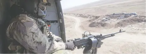  ?? RYAN REMIORZ / THE CANADIAN PRESS ?? A Canadian Forces door gunner keeps watch from a Griffon helicopter in northern Iraq. Canadian special forces continue to operate in the area.