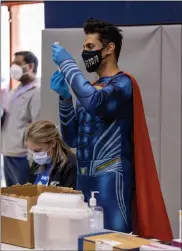  ?? PHOTO COURTESY BP MILLER/CHORUS PHOTOGRAPH­Y ?? Dr. Mayank Amin, a pharmacist and owner of Skippack Pharmacy dons a mask, gloves and his Superman suit while inside of North Penn High School on Sunday during a COVID-19 vaccinatio­n clinic. There were 3,000 doses administer­ed in a 12-hour period.