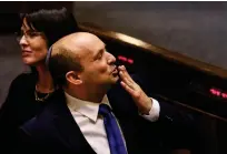  ?? (Ronen Zvulun/Reuters) ?? PRIME MINISTER Naftali Bennett leans back his head, and his kippah stays on.