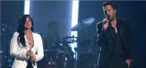  ?? MATT SAYLES/INVISION/AP ?? Demi Lovato and Luke Bryan performed “Penny Lover” for a tribute to MusiCares Person of the Year honoree Lionel Richie.