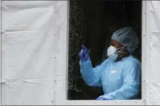  ?? JOHN MINCHILLO — THE ASSOCIATED PRESS ?? A medical worker gestures at a COVID-19testing station at The Brooklyn Hospital Center, Monday, March 23, 2020, in New York.