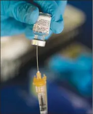  ?? (File Photo/AP/Rogelio V. Solis) ?? A Jackson-Hinds Comprehens­ive Health Center nurse loads a syringe with the Pfizer covid-19 booster vaccine Nov. 18 at an inoculatio­n station next to Jackson State University in Jackson, Miss. “Omicron,” the persistent covid-19 variant that has been responsibl­e for numerous infections in 2022, was one of the top 10 most searched terms on merriam-webster.com in 2022.