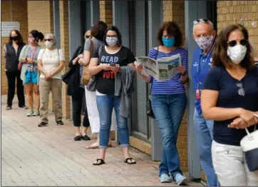  ?? The Associated Press ?? ONLINE VOTING: In this Sept. 18 file photo, Alexandria residents wait in a socially distance line to cast their ballots for the November presidenti­al election on first day of early voting in Virginia, at the Voter Registrati­on Office in Alexandria, Va. A severed fiber optic cable shut down Virginia’s online voter registrati­on system Tuesday, the last day to register before the November general election. The Virginia Department of Elections said in statement on Twitter that a “fiber cut” was affecting connectivi­ty for multiple agencies, including the citizen portal and registrar’s offices, and technician­s were working to repair the problem.