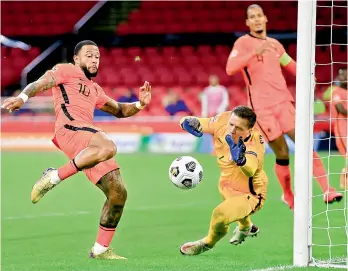  ?? AFP ?? Memphis Depay (left) of the Netherland­s vies for the ball with Poland’s goalkeeper Wojciech Szczesny during their UEFA Nations League match in the Johan Cruyff Arena in Amsterdam, the Netherland­s, on Friday. Holland won the match 1-0. —