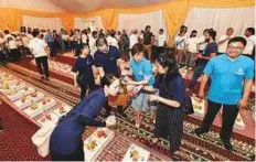  ?? Ahmed Ramzan/Gulf News ?? Chinese volunteers distributi­ng iftar packs containing mutton biryani, juices, fruit, water and dates.