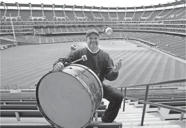  ?? AP ?? John Adams poses in his usual center field bleacher seat with his ever-present bass drum before a game against the Royals in 2011. Adams pounded a drum while sitting in Cleveland’s outfield bleachers during games for five decades.