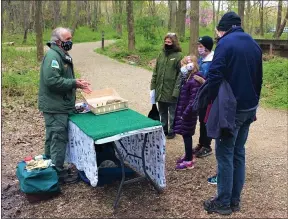  ?? CHAD FELTON — THE NEWS-HERALD ?? Wildlife Education Specialist Fred Murch, left, greets Penitentia­ry Glen visitors during the property’s Earth Day celebratio­n on April 25. Several guided hikes were held during the event which had a limit of registrant­s due to COVID-19.